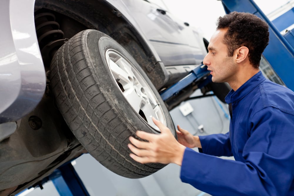 Mechanic repairing a car wheel at the garage